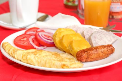 内罗毕KAP Guest House的包括鸡蛋香肠和西红柿的早餐食品
