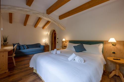 圣马蒂诺-迪卡斯特罗扎Hotel Stalon Alpine Chic的一间卧室配有一张白色大床和蓝色沙发