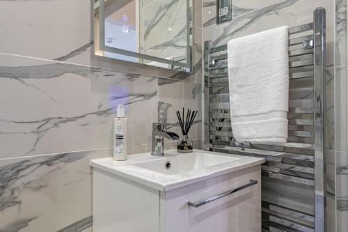 霍利黑德The Cove的白色的浴室设有水槽和镜子