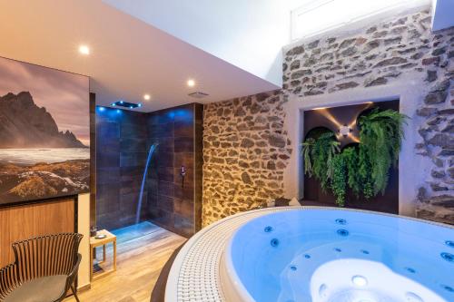 Vaux-en-BeaujolaisAuberge de Clochemerle, Spa privatif & restaurant gastronomique的大型浴室设有大型蓝色浴缸。