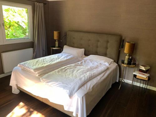 沃格尔Gartenparadies inmitten Wörgl的一间卧室配有一张带白色床单的床和一扇窗户。