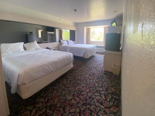 麦卡莱斯特Studio 6 McAlester OK South的酒店客房设有两张床和窗户。