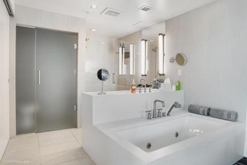 劳德代尔堡Luxury Well stocked SE Corner 2BR W Fort Lauderdale w Great Ocean Views的白色的浴室设有大浴缸和淋浴。