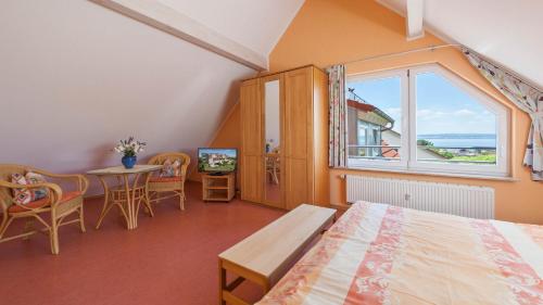 哈格瑙Sonnenhof Hagnau的一间卧室配有一张床、一张桌子和一个窗户。