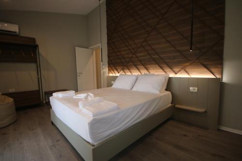 希马拉Alyvia Rooms的一间卧室配有带白色床单和枕头的床。