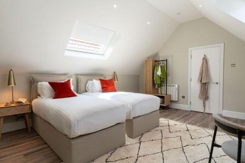 布里斯托Wellington Place I Your Apartment的一间卧室配有两张带红色枕头的床