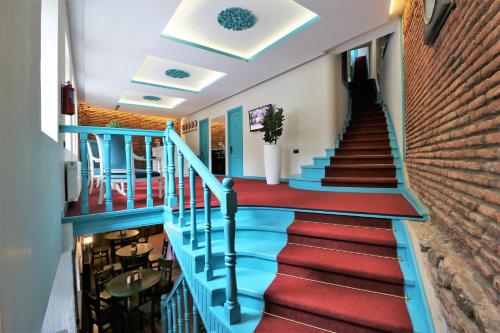 第比利斯City Inn Tbilisi的建筑中的一个楼梯,有蓝色和红色的楼梯