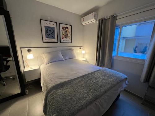 EncantadoApartamento Confortável的一间卧室设有一张大床和窗户