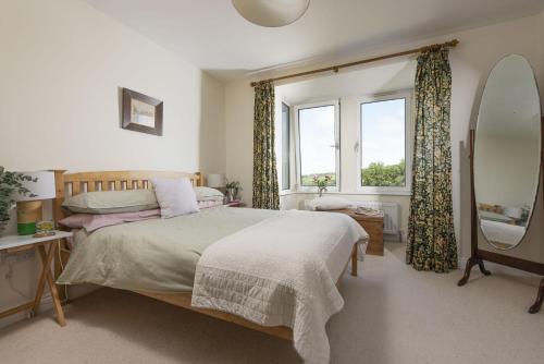 波斯科诺Treen House, Porthcurno的一间卧室设有一张床和一个窗口
