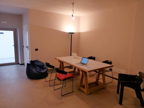 维戈迪卡多雷Casa della Rosa Dolomites experience的配有桌椅的房间,上面有笔记本电脑