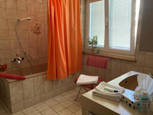 FrenkendorfKonditor B & B的浴室内配有橙色淋浴帘和水槽