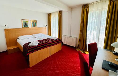 班斯卡 - 什佳夫尼察马捷豪华大酒店 的酒店客房,配有一张铺有红地毯的床