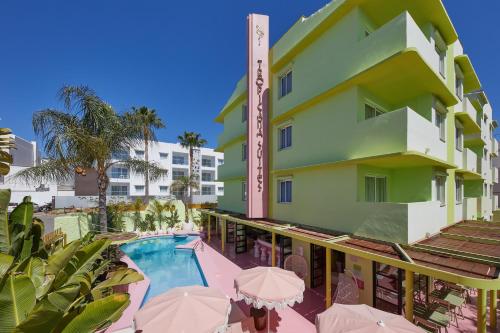 普拉亚登博萨Tropicana Ibiza Suites - Adults Only的享有酒店的景致,设有游泳池和遮阳伞