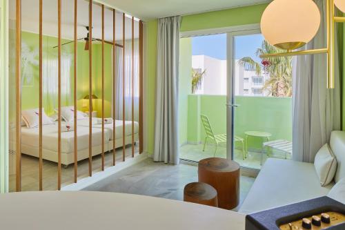 普拉亚登博萨Tropicana Ibiza Suites - Adults Only的一间卧室设有一张床和一个阳台