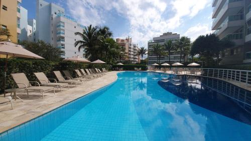 圣劳伦斯海滨Alugar na Riviera Hotel Ilha da Madeira Resort的一个带椅子和遮阳伞的大型游泳池