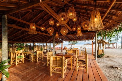 班泰All At Sea Beach Resort的海滩上的餐厅,配有桌椅