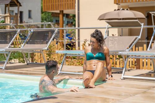 莱德罗托里公寓式酒店的游泳池里的男人和女人