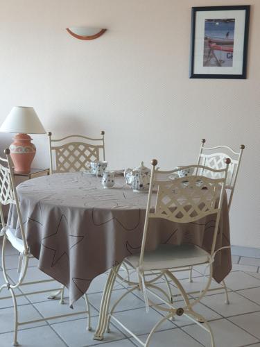 格朗维尔Le Guépratte的餐桌、椅子、桌子和台灯