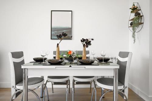 UrmstonIdeal Lodgings In Urmston的白色的餐桌、椅子和白色的墙壁