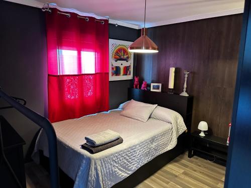 普埃托利亚诺KB HOME Puertollano的一间卧室配有一张带红色窗帘的床