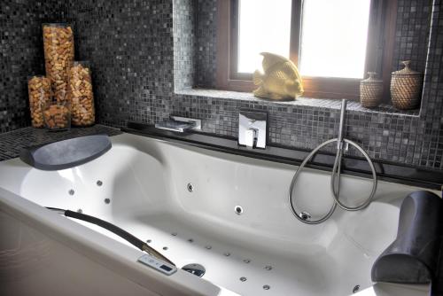 赫雷斯-德拉弗龙特拉Home Apartments Jerez的带窗户的浴室内的白色浴缸