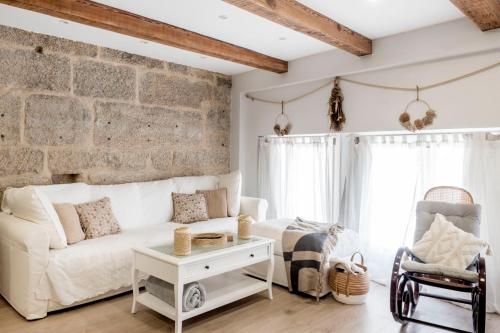 维戈Casa MIMOSA Vigo的客厅配有白色沙发和砖墙