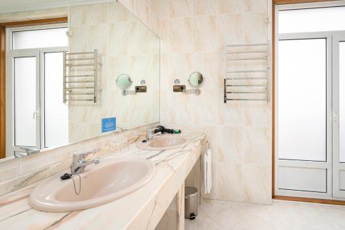 希洪埃尔南科尔特斯酒店的一间带两个盥洗盆和大镜子的浴室
