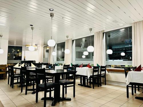 格拉鲁斯Hotel Stadthof Glarus的用餐室设有桌椅和窗户。