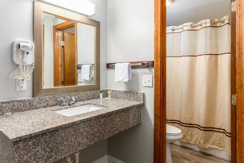伊斯特姆队长宿舍汽车旅馆&会议中心的一间带水槽、卫生间和镜子的浴室