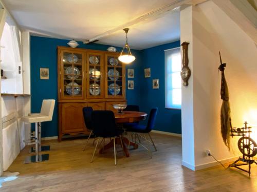 利克维Laterale Residences Riquewihr的一间拥有蓝色墙壁和桌椅的用餐室