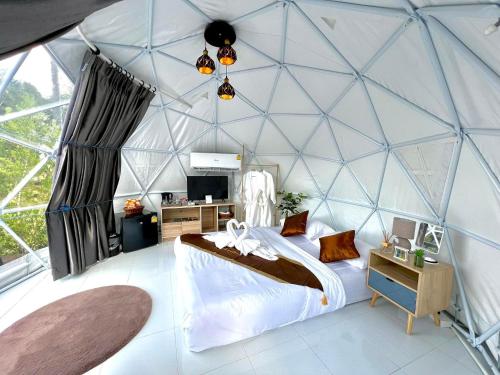Ban Song Phi Nongเคียงดาว โฮมสเตย์ แก่งกระจาน的圆顶帐篷内的卧室配有1张床和1张书桌