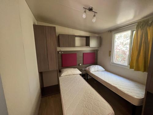 索托马里纳Chalet sulla spiaggia的客房设有两张床和窗户。