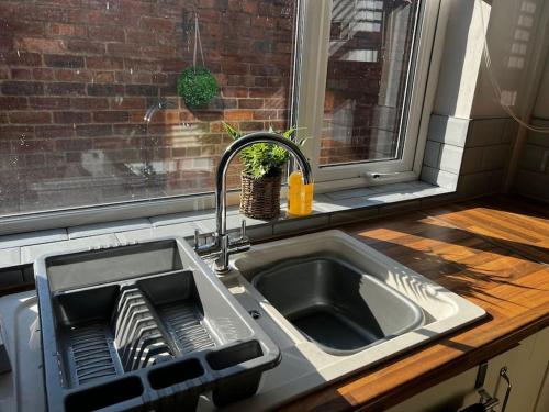 切斯特The Gladstone terrace的厨房水槽,窗户旁设有碗碟干燥架