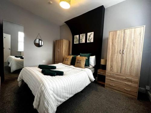 切斯特The Gladstone terrace的一间卧室配有一张带白色床单和绿色枕头的大床。