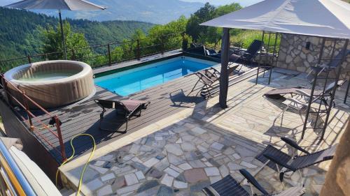 萨拉热窝Villa unforgettable的一个带游泳池、椅子和遮阳伞的甲板