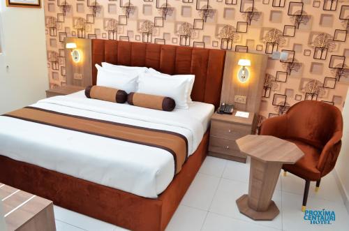 哈科特港Proxima Centauri Hotel的一间卧室配有一张大床和一把椅子