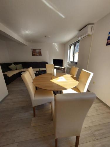 亚伊采Apartman Trupsi的一间带木桌和椅子的用餐室