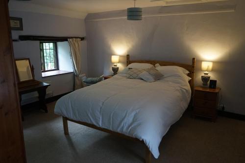 沙夫茨伯里Character 2 double bedroom cottage in Shaftesbury的一间卧室配有一张带两盏灯的大型白色床。
