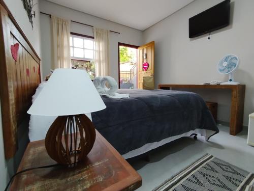 蒂拉登特斯Pouso Casa da Vovó的一间卧室配有一张床和一张带台灯的桌子