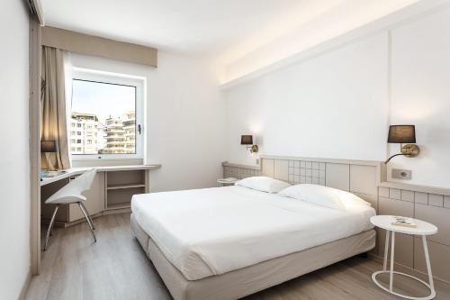 萨萨里卡罗费利切酒店的白色的卧室设有床、书桌和窗户