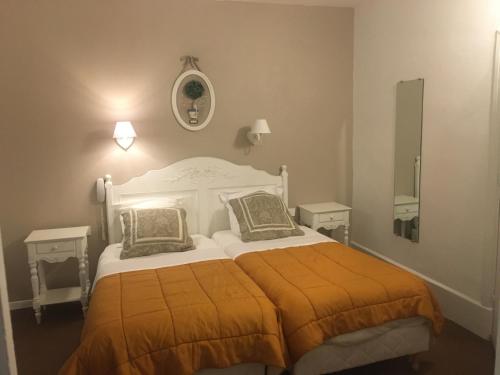 索伊茨HOTEL LES MARRONNIERS的一间卧室配有一张带橙色毯子的大床