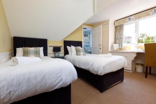 伯恩茅斯Cransley Apart Hotel的酒店客房带两张床和一间浴室