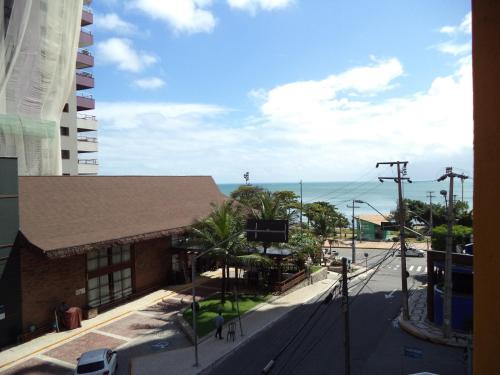 福塔莱萨Netuno Beach Hotel的一座以大海为背景的街道上的建筑