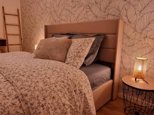 米卢斯Les Alliés的一间卧室配有一张床和一张桌子上的台灯