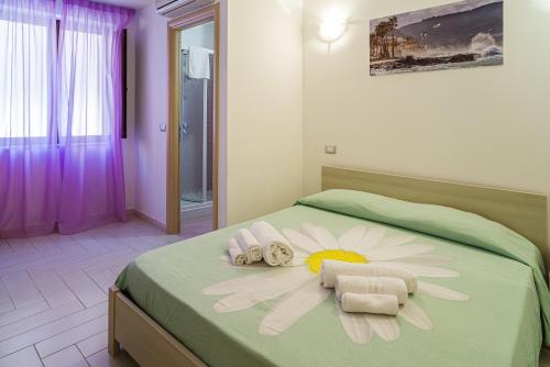 圣塔马里亚迪卡斯特拉玛利亚酒店的一间卧室配有带毛巾和鲜花的床