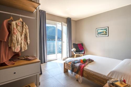 奥梅尼亚d'Ocalée Holiday Experience lago d'Orta的一间卧室设有一张床、一个窗口和一把椅子