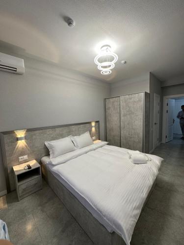 塔什干ReveL HoteL的一间卧室配有一张大床和一个吊灯。