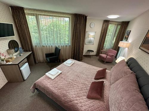 哈斯科沃Хотел АВРОРА的酒店客房设有一张大床和一张书桌。