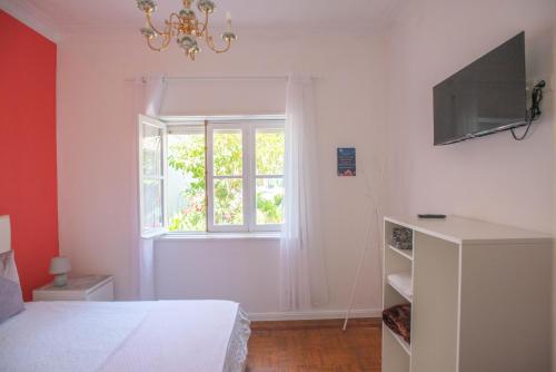 Senhora da HoraHostel das Flores的一间卧室设有一张床和一个窗口