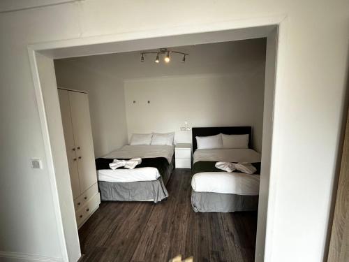 莱斯里普The Ruislip Apartment的小房间设有两张床和镜子